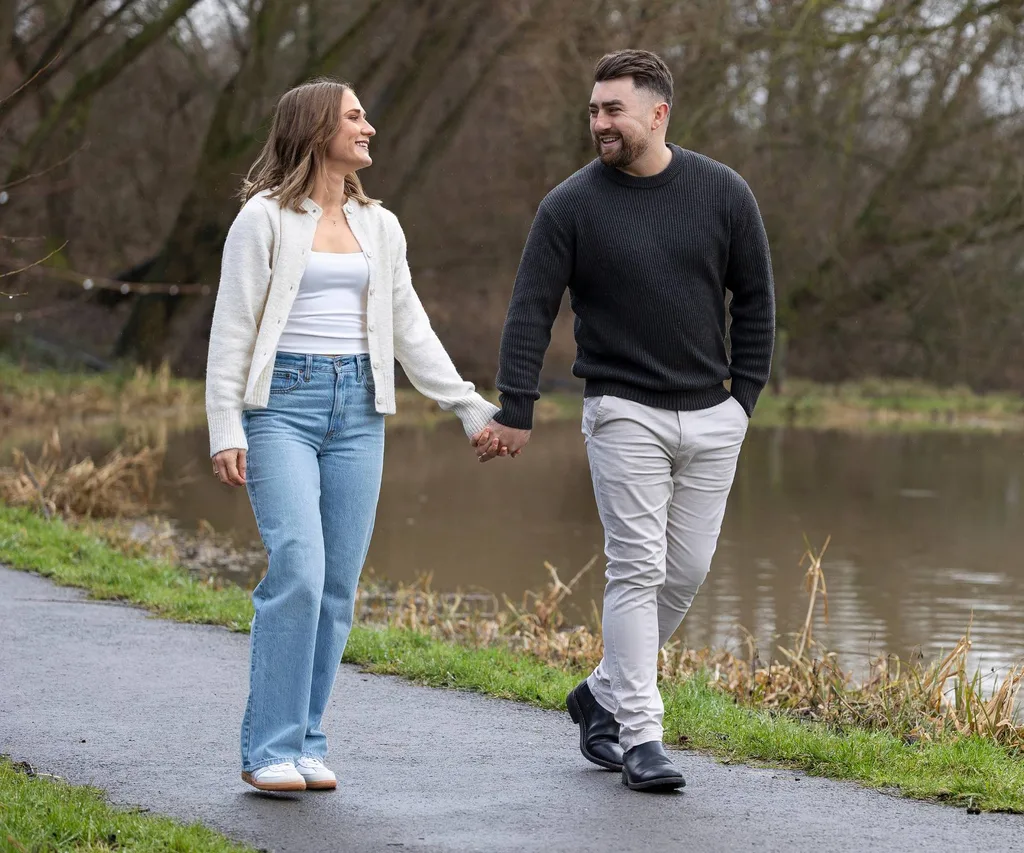 Man and woman walking in park engaged