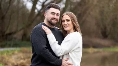 Man and woman standing in park engaged