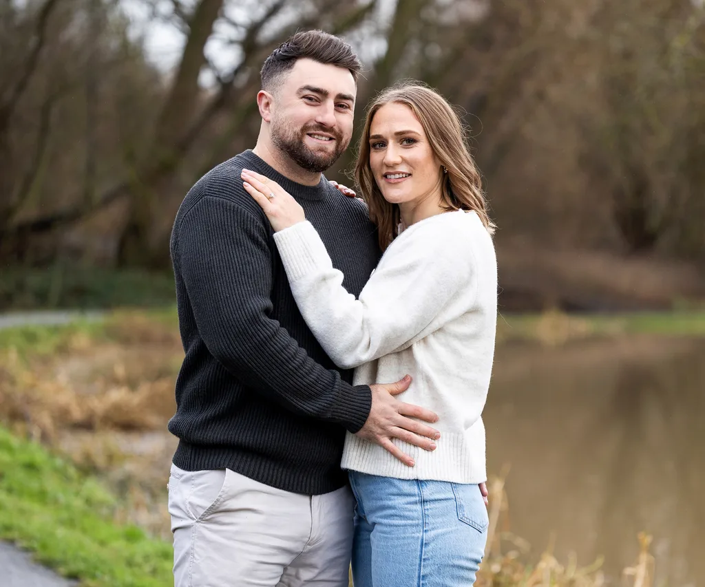 Man and woman standing in park engaged