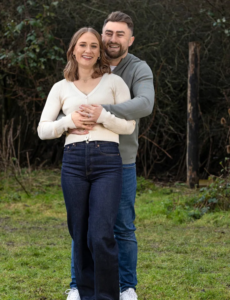 Man and woman standing in park engaged