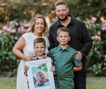 Effie's mum, dad and brothers holding a picture of her
