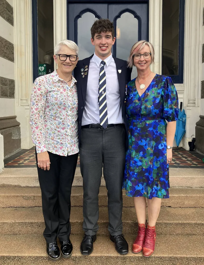 Two Mums with their son as he wear his school uniform
