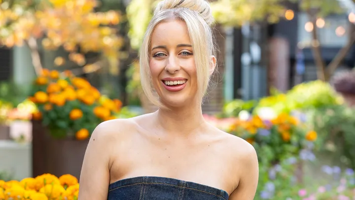 MAFS Jamie wearing denim jumpsuit with potted yellow flowers in background