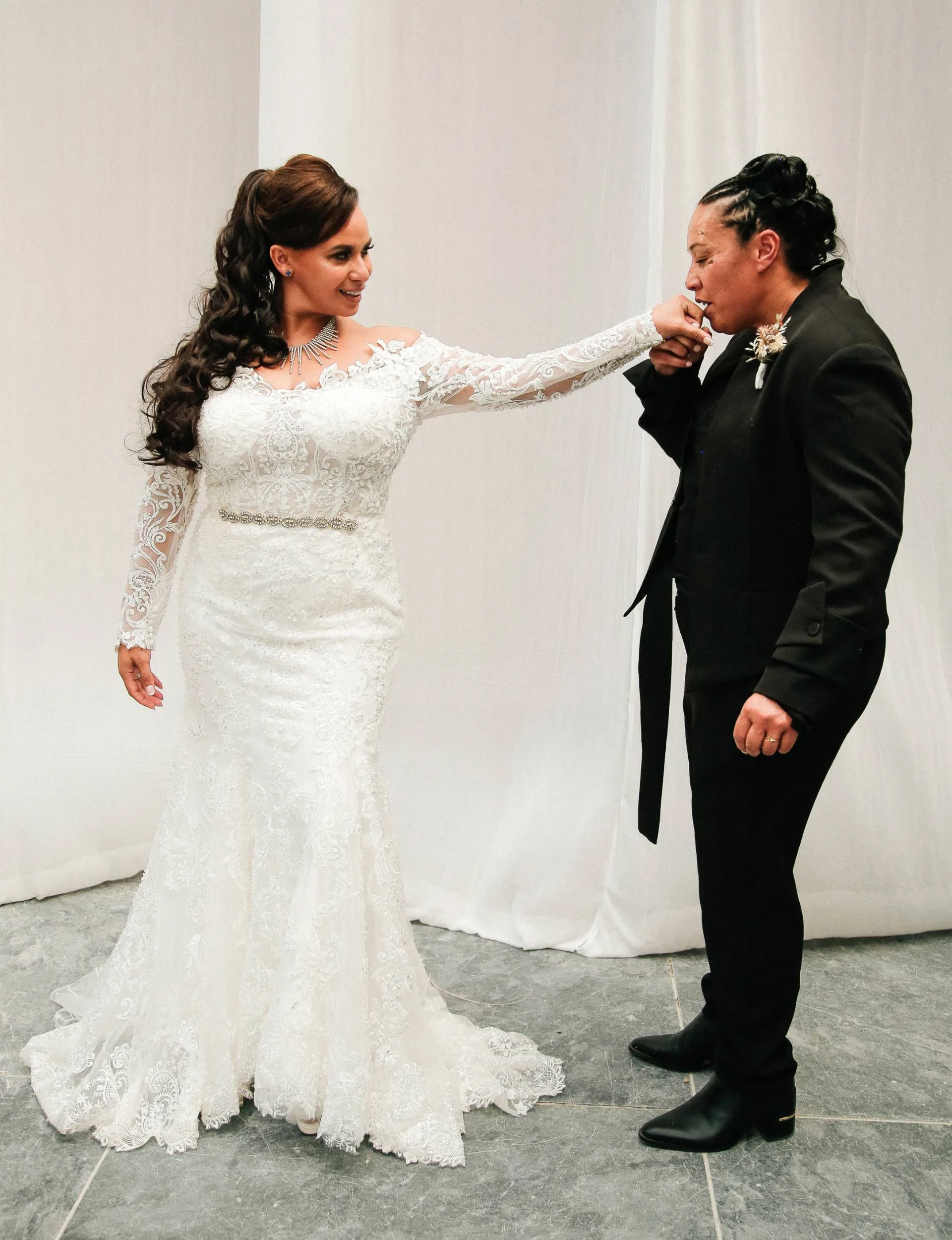 Natalie McDade kissing Megan Alatini's hand on their wedding day