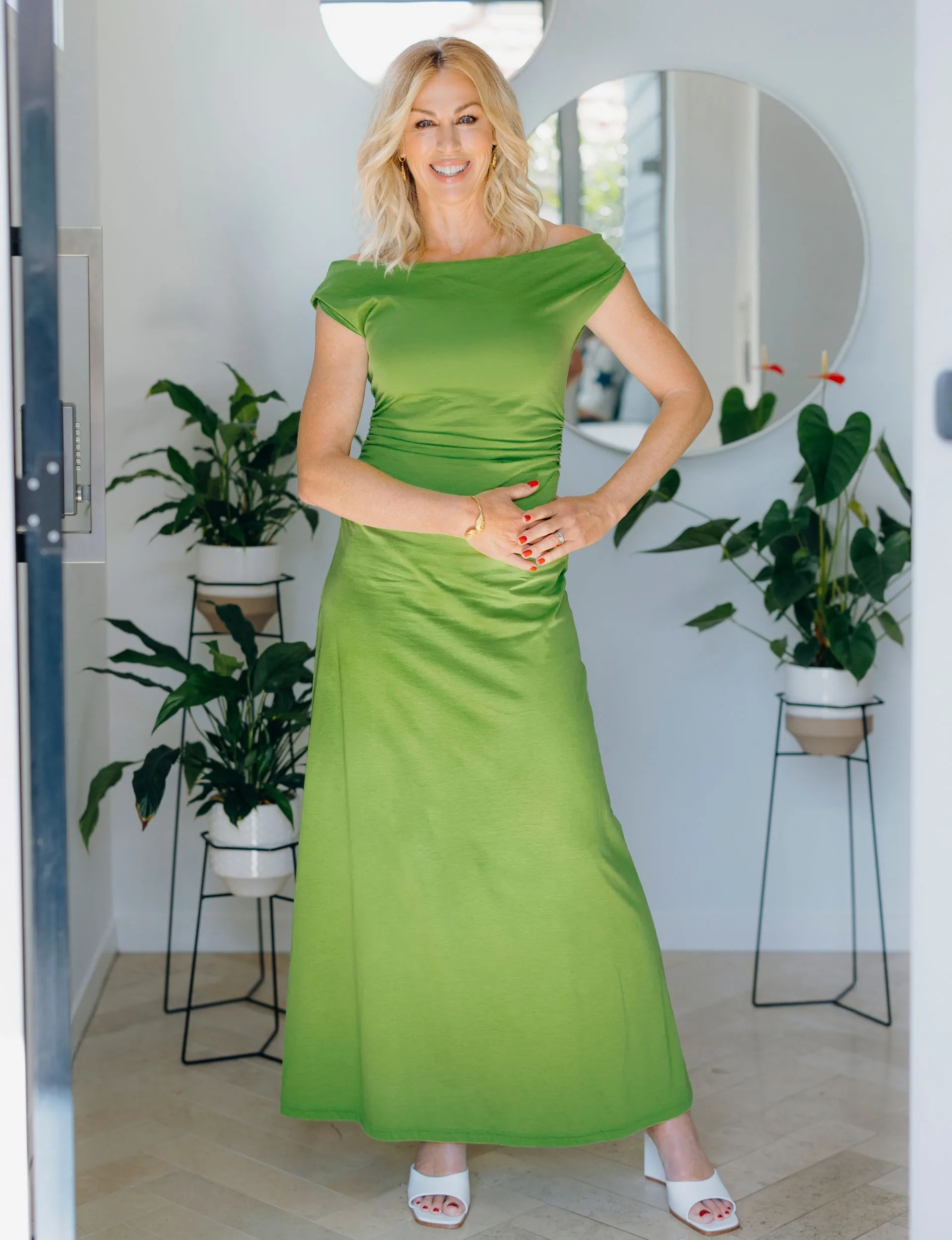 Wendy Petrie posing with her hand on her hip in a green dress