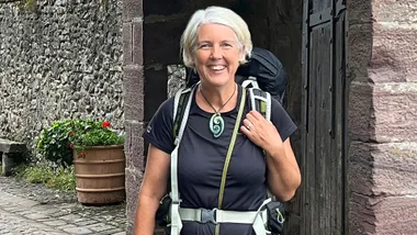 Jennifer Andrewes smiling in an archway with a backpack in France
