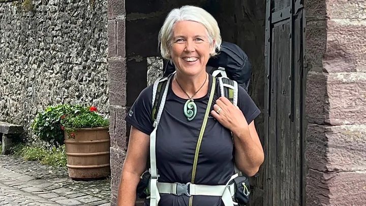 Jennifer Andrewes smiling in an archway with a backpack in France