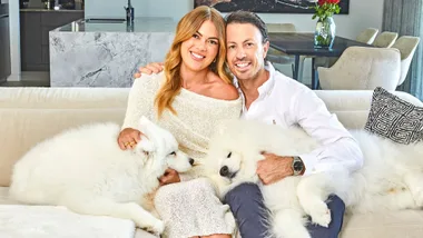 Jacqui and Clint with his two fluffy dogs on a couch