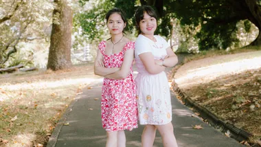 sisters alisa vicky standing side by side in park