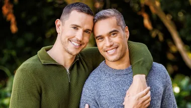 Harry McNaughton with his arm around husband Koro's neck