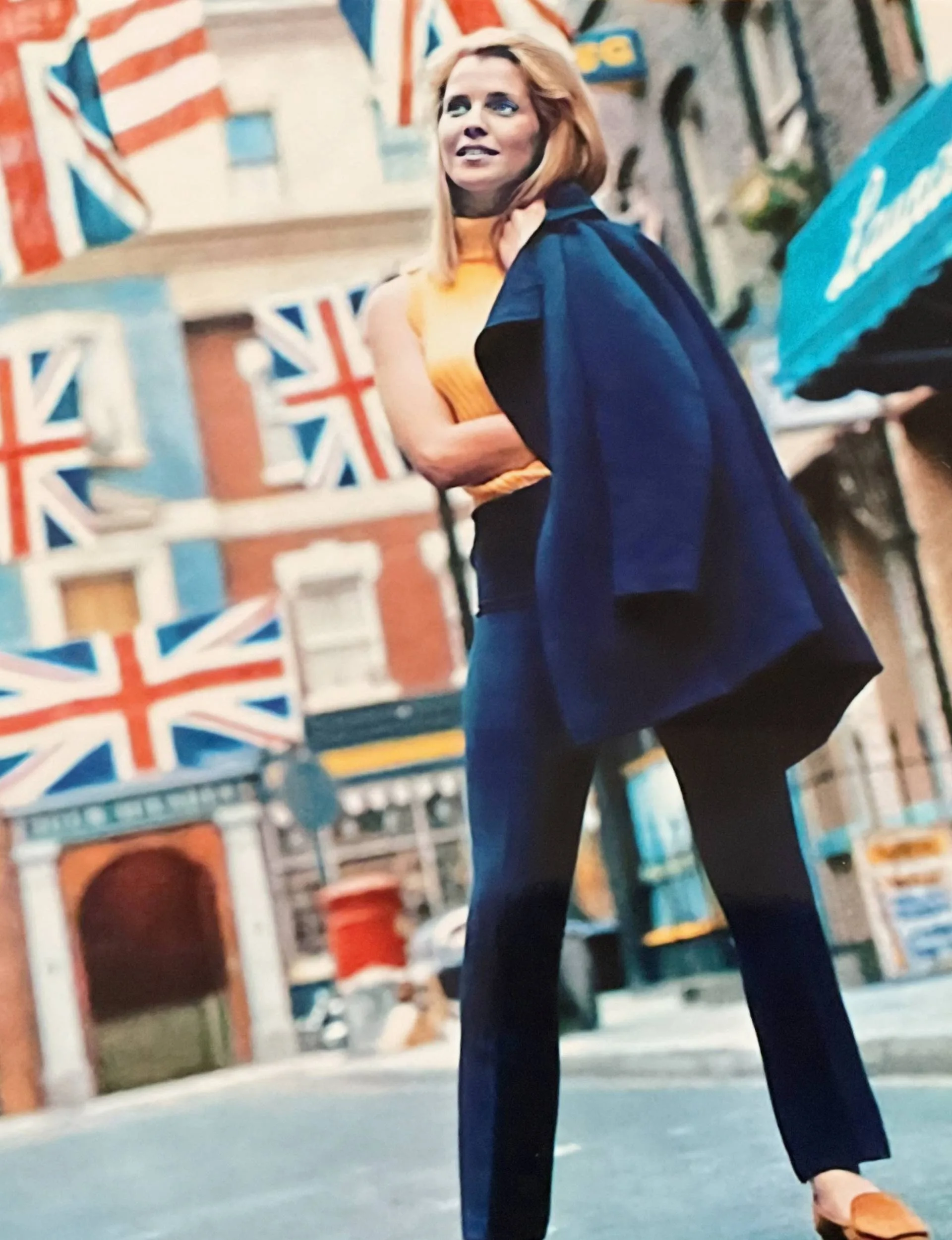 Ilona Rodgers on a street as a young woman, with British flags hanging everywhere overhead