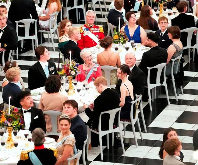 The queen with her companions sitting in a dining hall at Princess Isabella's 18th birthday