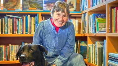 Ruth Shaw with her dog in a library