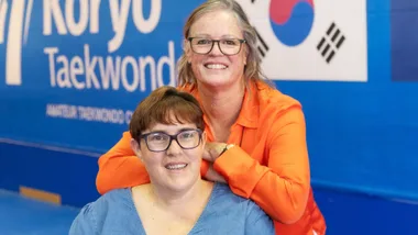 Lorraine Bainbridge in her taekwondo club with trainer Camille behind her