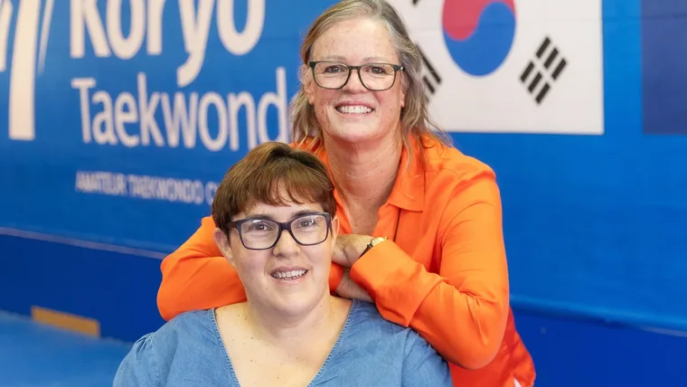 Lorraine Bainbridge in her taekwondo club with trainer Camille behind her