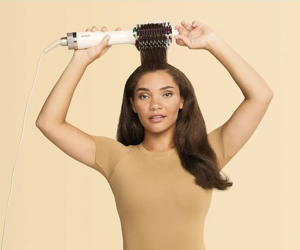 brunette model using a hair styling tool