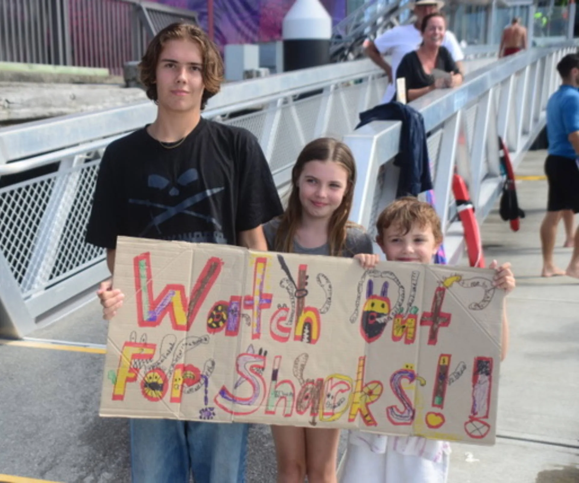 Bruce Hopkins' grandchildren supporting him with a sign drawn on a piece of cardboard