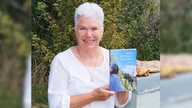 Josie Laird holding up her book about bees, Miss Bumby's Mission