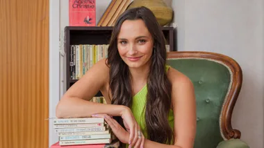 Mirabai Pease leaning on a stack of Agatha Christie books