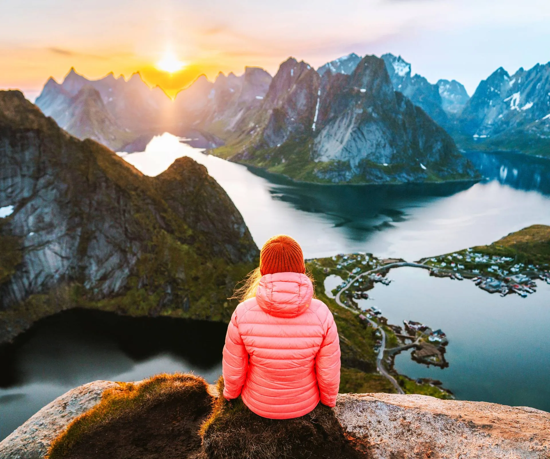 A woman on a mountain top looking over a mountain and lake view