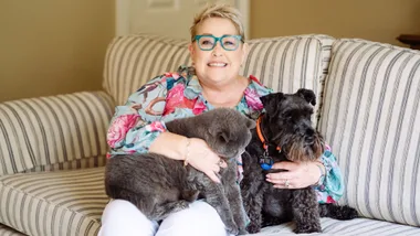 Suzanne Prentice on her couch at home with her cat and dog