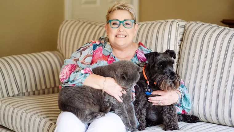 Suzanne Prentice on her couch at home with her cat and dog