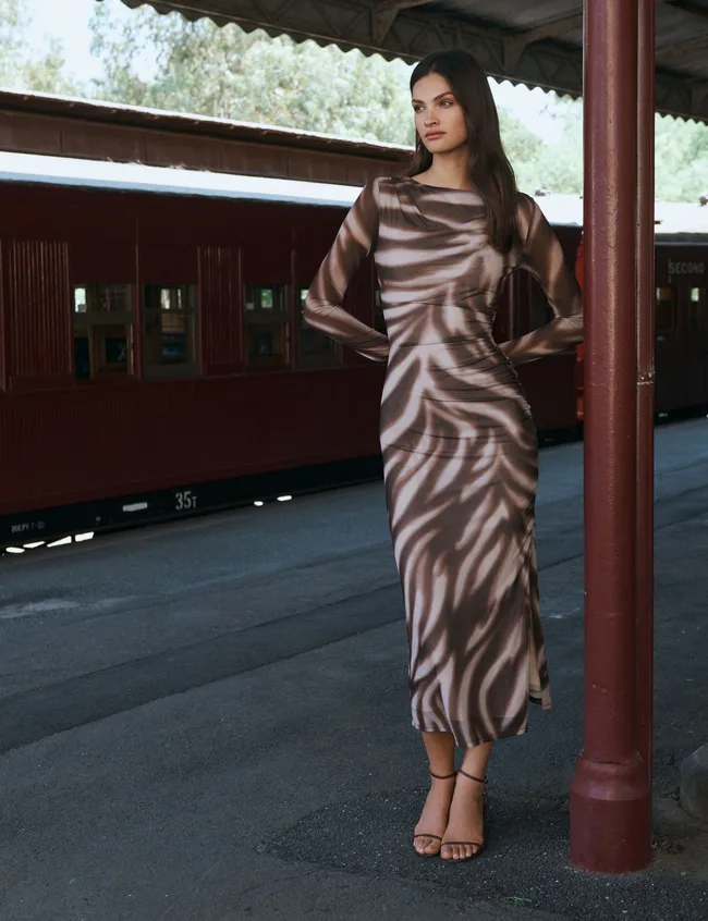 Model wearing Forever New mesh dress at train station