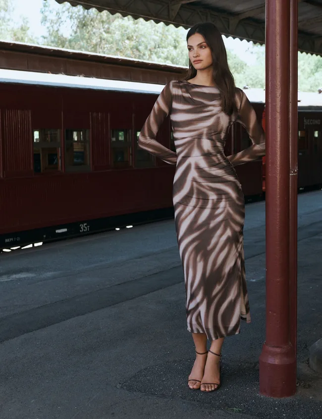 Model wearing Forever New mesh dress at train station