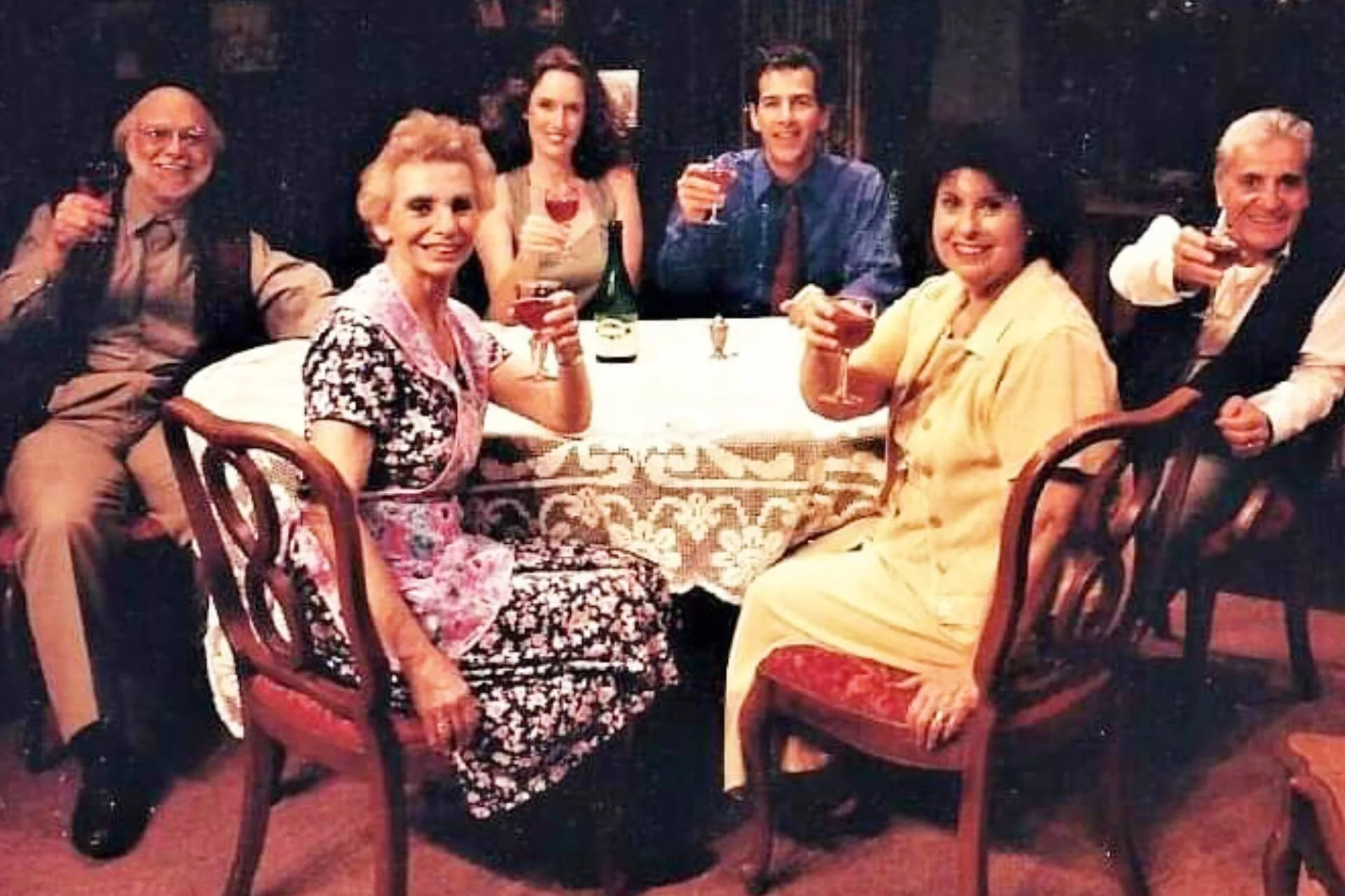 Lara Macgregor sitting around a round table sharing a toast with her old castmates