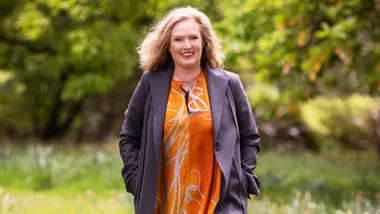 Lara Macgregor walking towards the camera with her hands in her cardigan pockets