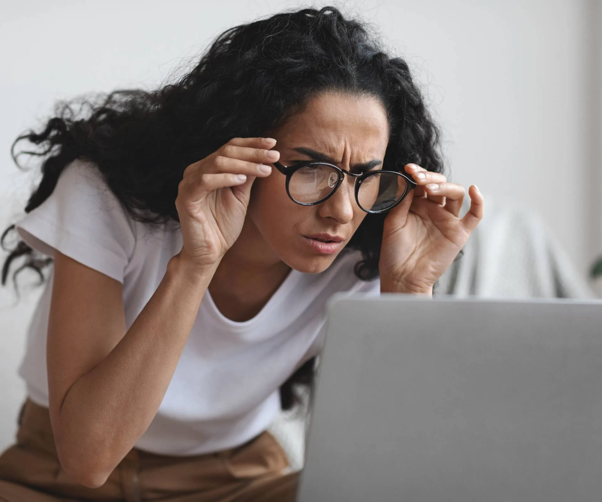 A woman frowning and squinting at her laptop, trying to make the yes effect work