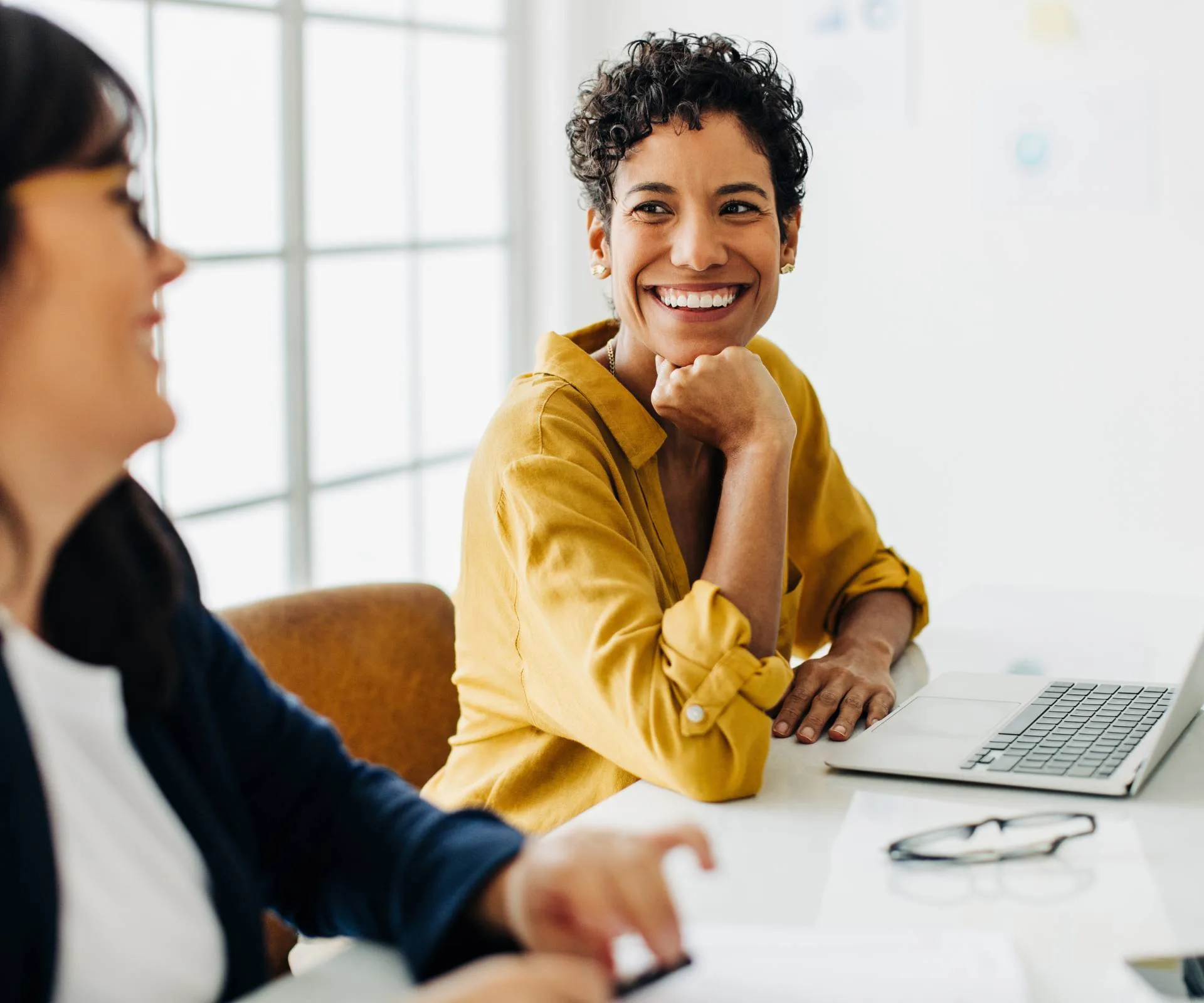 Two women smiling in their workplace