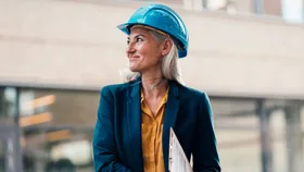 A business woman wearing a hard hat on a construction site