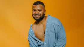 Joe Daymond in front of an orange backdrop