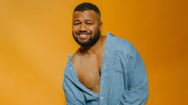 Joe Daymond in front of an orange backdrop