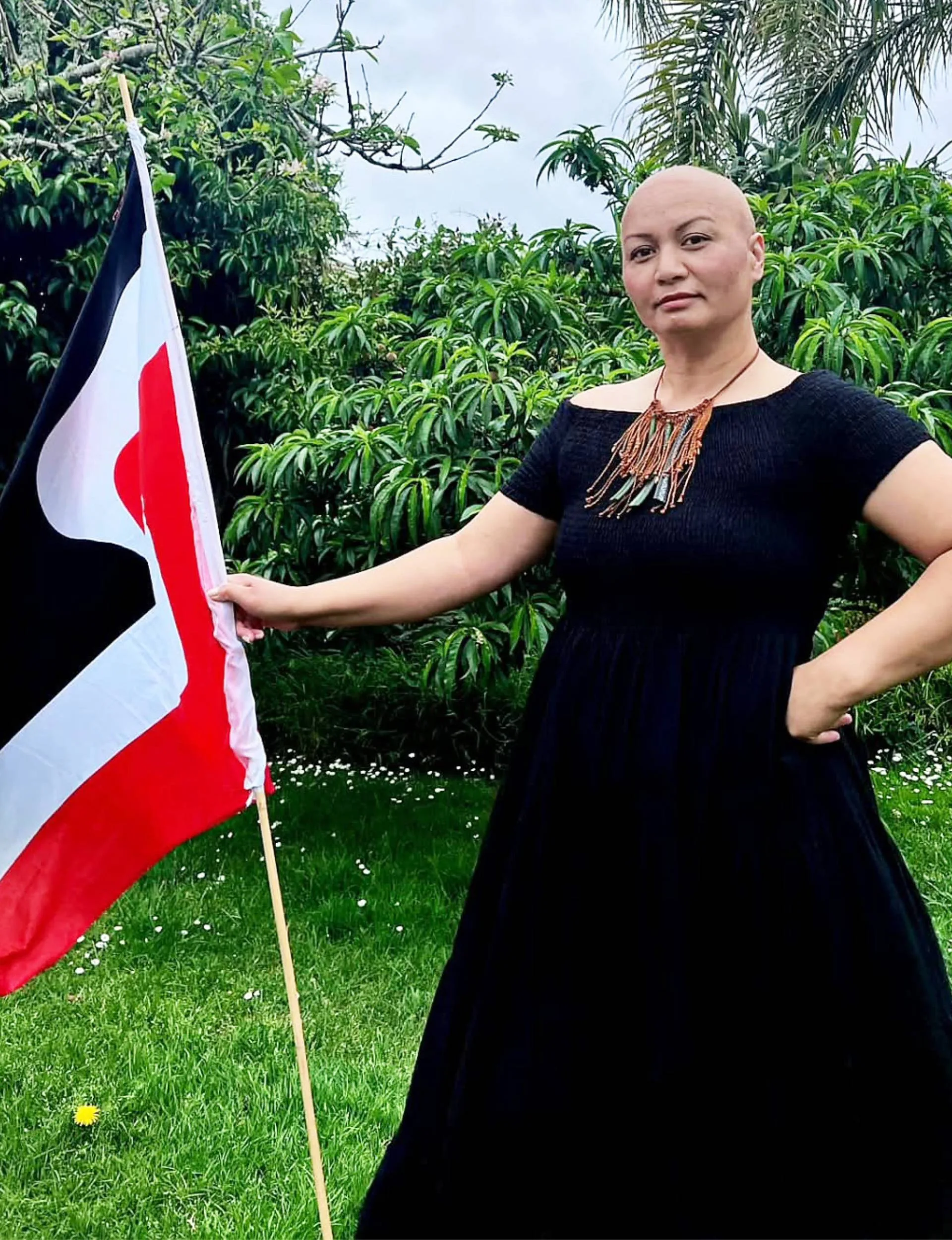 Marama Davidson during her cancer treatment holding a Maori flag