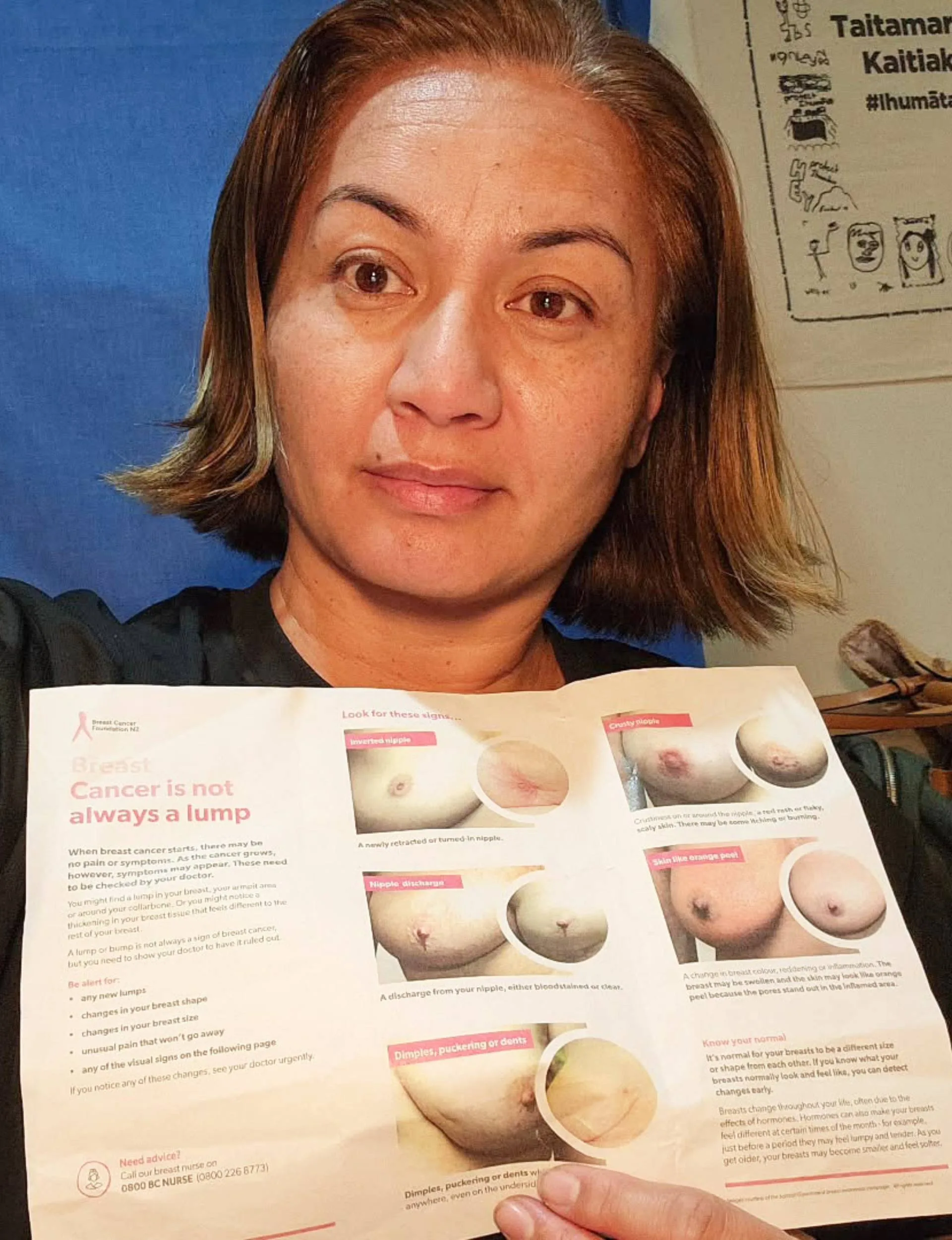 Holding up a breast cancer pamphlet