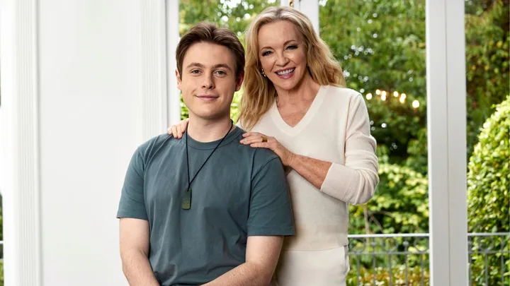 Rebecca Gibney standing beside her son, Zac sitting on the arm of a couch