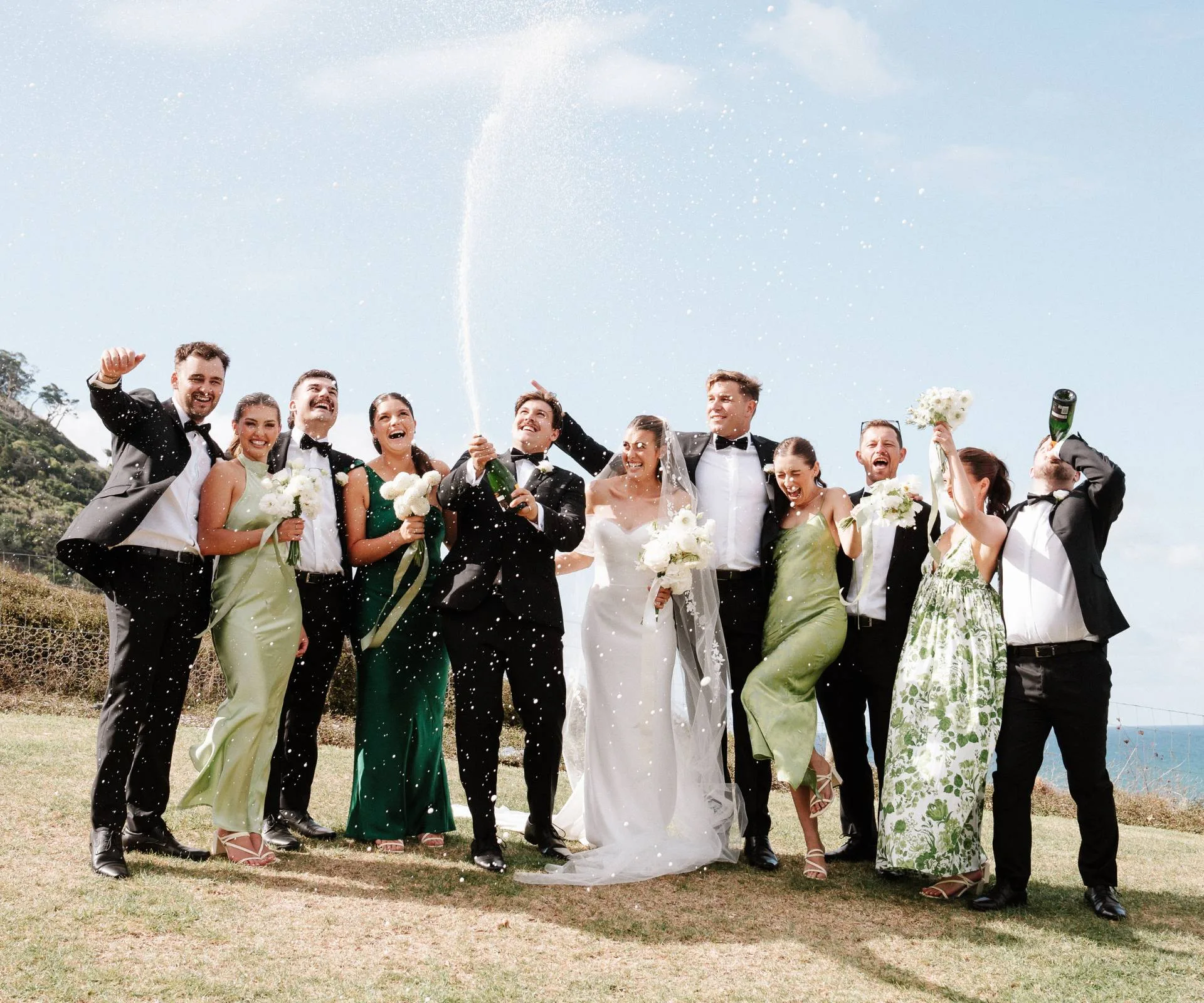 Healthy Kelsi and her husband popping champagne with their bridal party and groomsmen