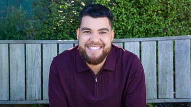 Te sitting in a wooden outdoor chair