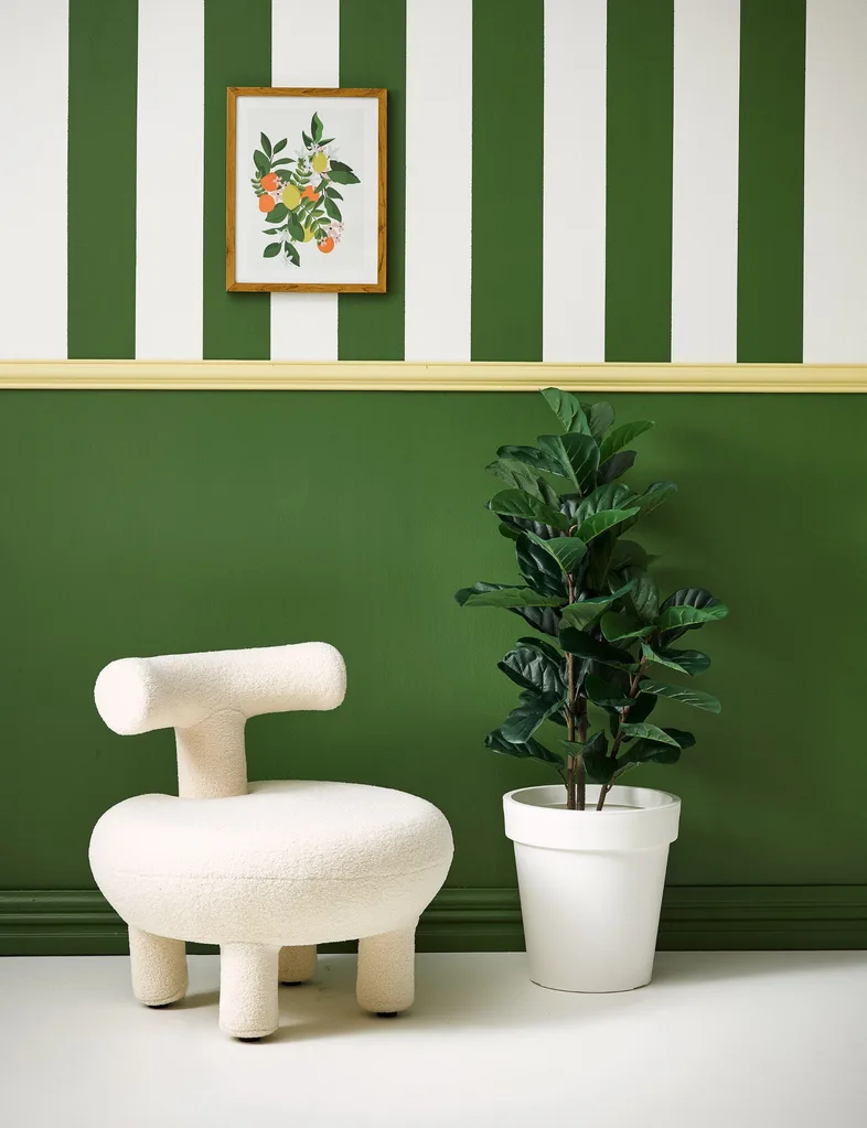 Top half of this wall is painted in green and white stripes, bottom half in green with decor echoing the wall colours