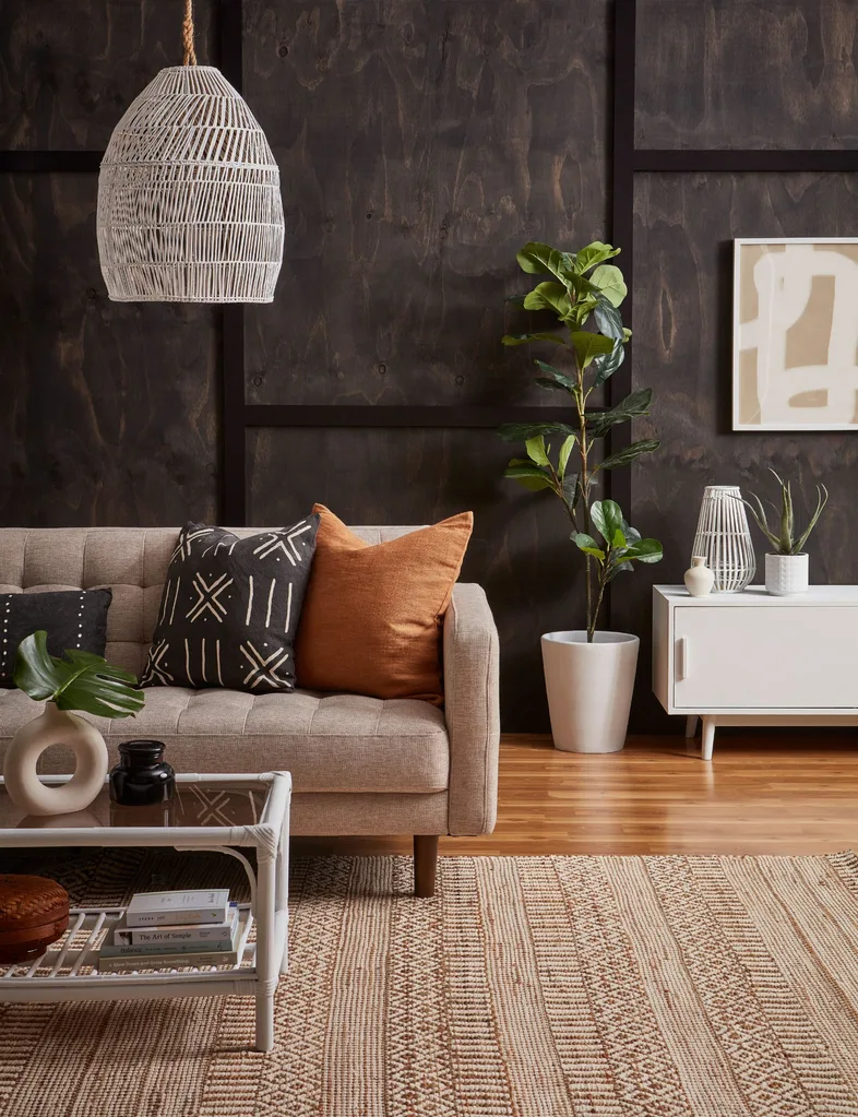 The stained wood and natural pattern of the wood adds interest in this living room. Orange, white and beige touches add to the autumn colour palette