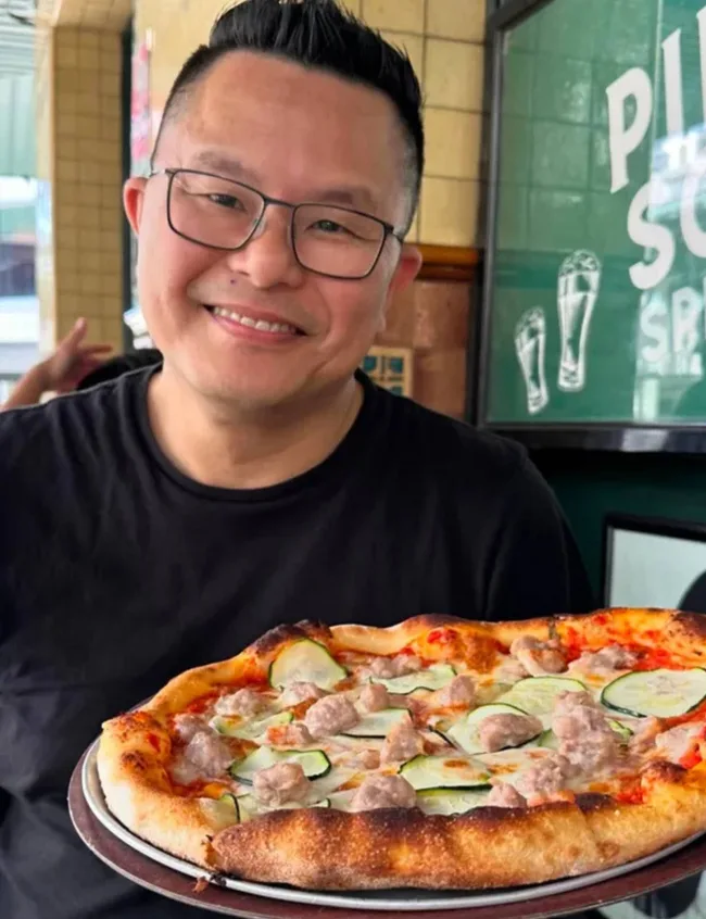 Jimmy Wong holding a large pizza