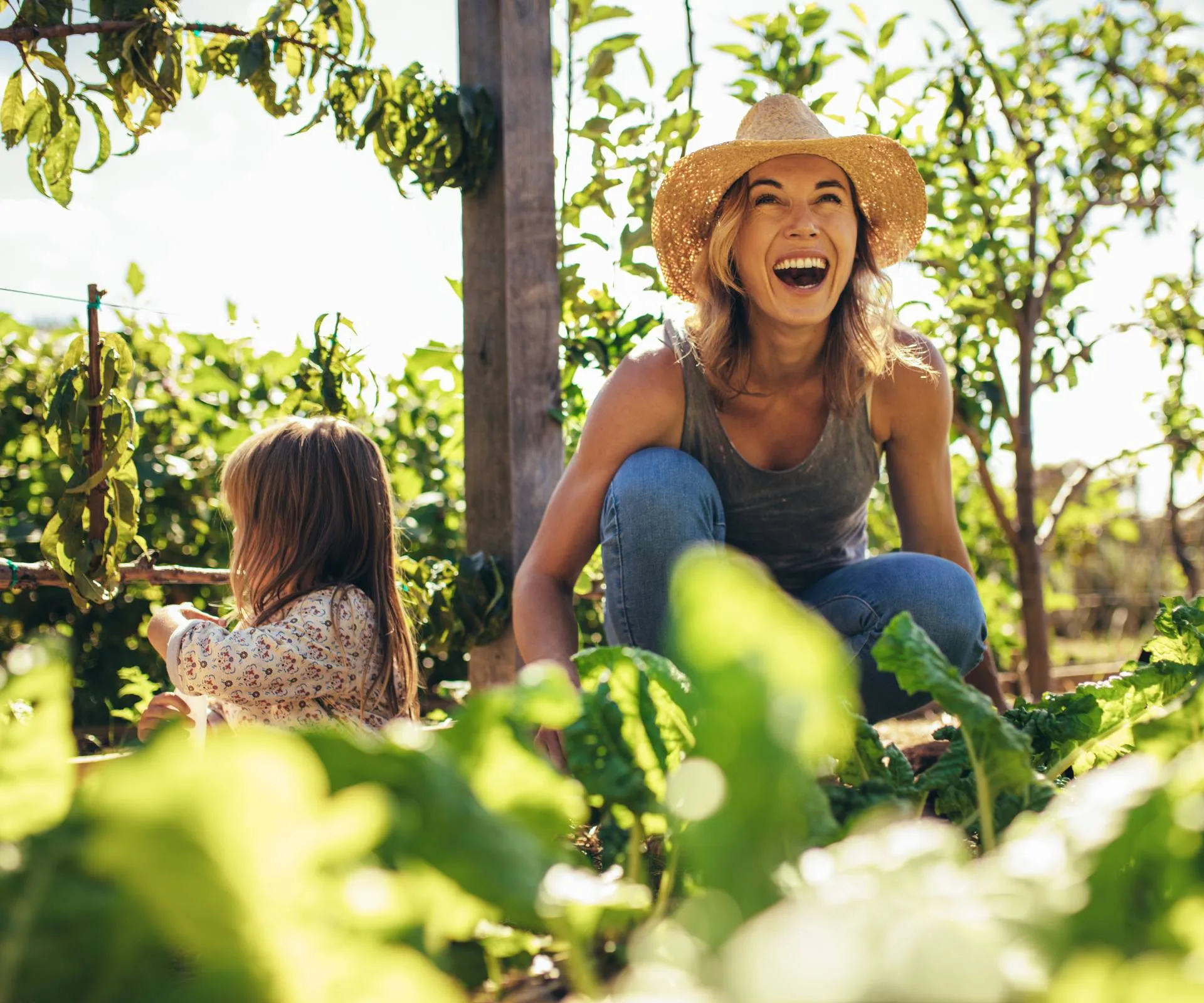 A mum and her daughter in the garden growing garlic