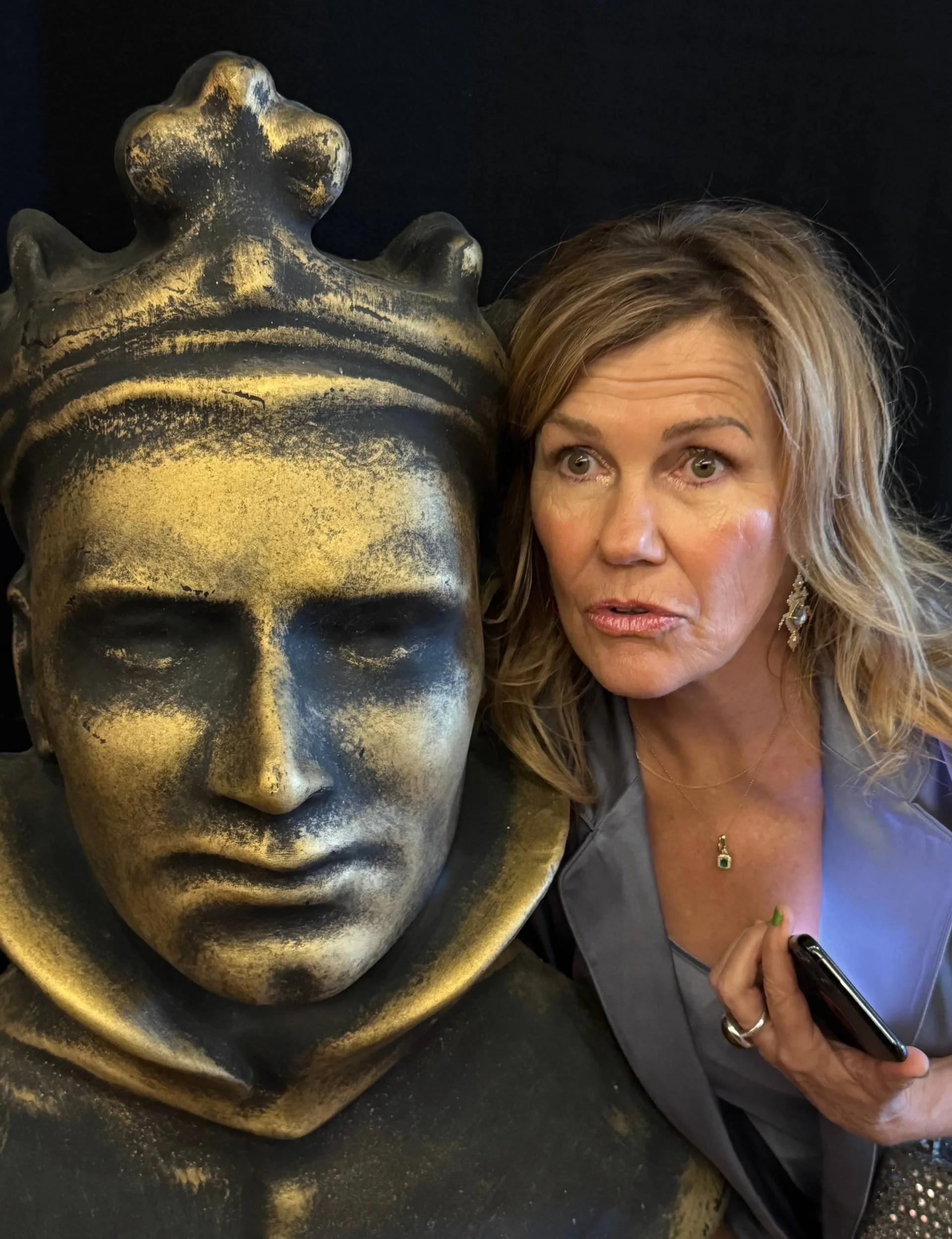 Robyn Malcolm posing with a gold statue