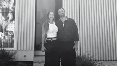 Andy Allen with his wife in front of their new home