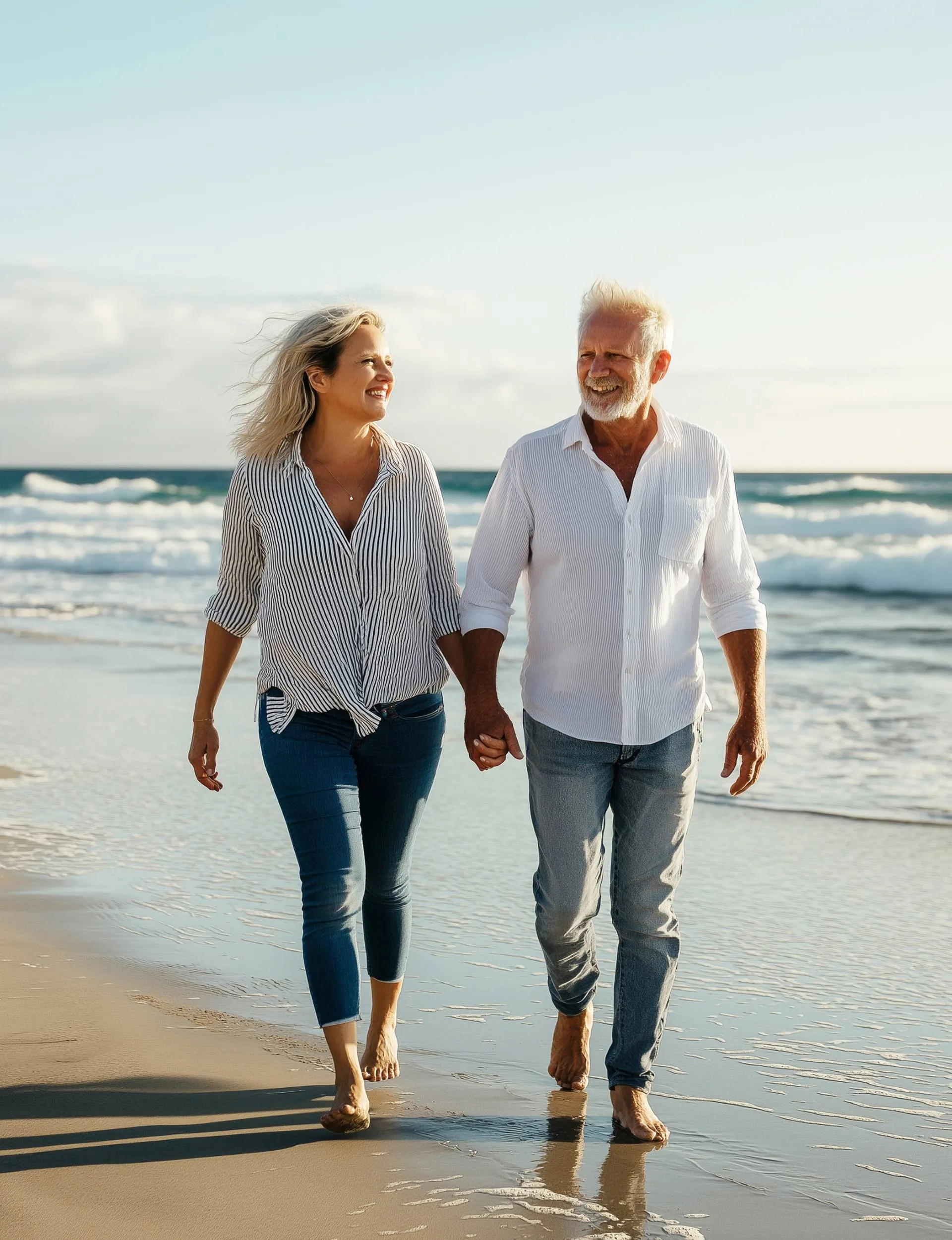 A couple over 50 walking down a beach together