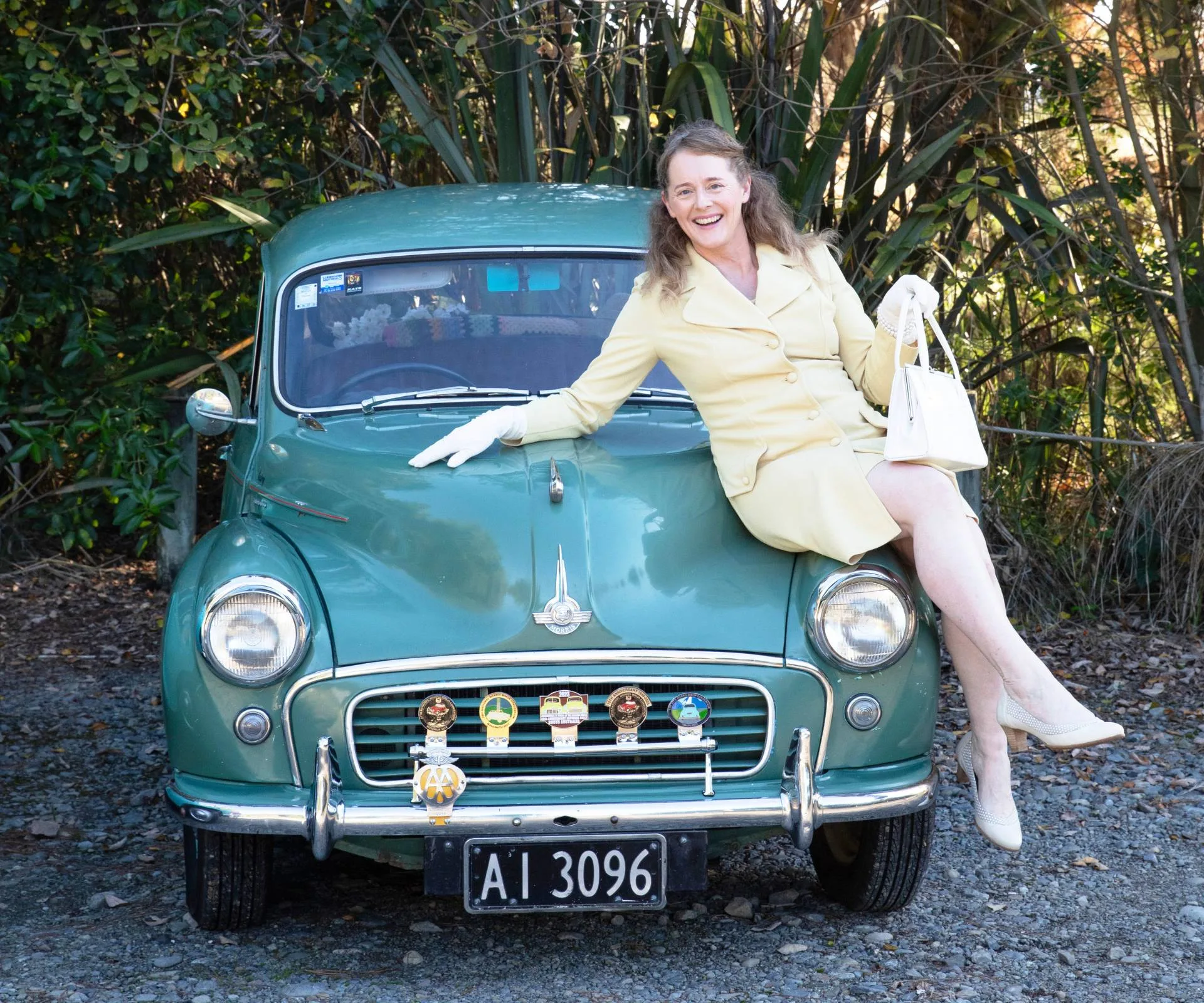 Anita sitting on the bonnet of her green Morris Minor