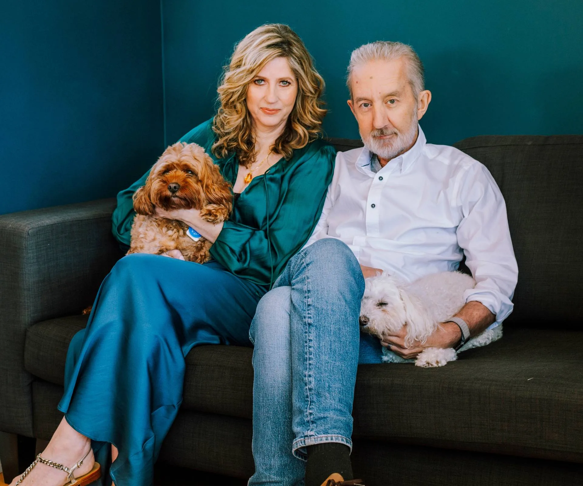 Nigel Latta sitting on a couch with his wife Natalie and their two dogs