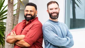 Between Two Beers podcast hosts standing back to back